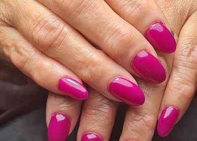 Vibrant magenta nails manicure at Ria Dharni, Crawley, England, GB, showcasing elegant nail art design.