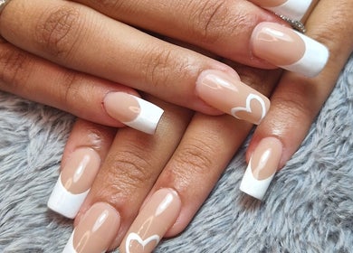 Elegant French manicure with heart designs at Ria Dharni in Crawley, England, GB.
