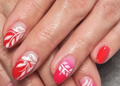 Elegant floral nail art with red and pink hues at Ria Dharni, Crawley, England, GB.