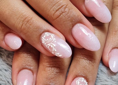 Elegant pink gel nails with floral design at Ria Dharni, Crawley, England, GB.