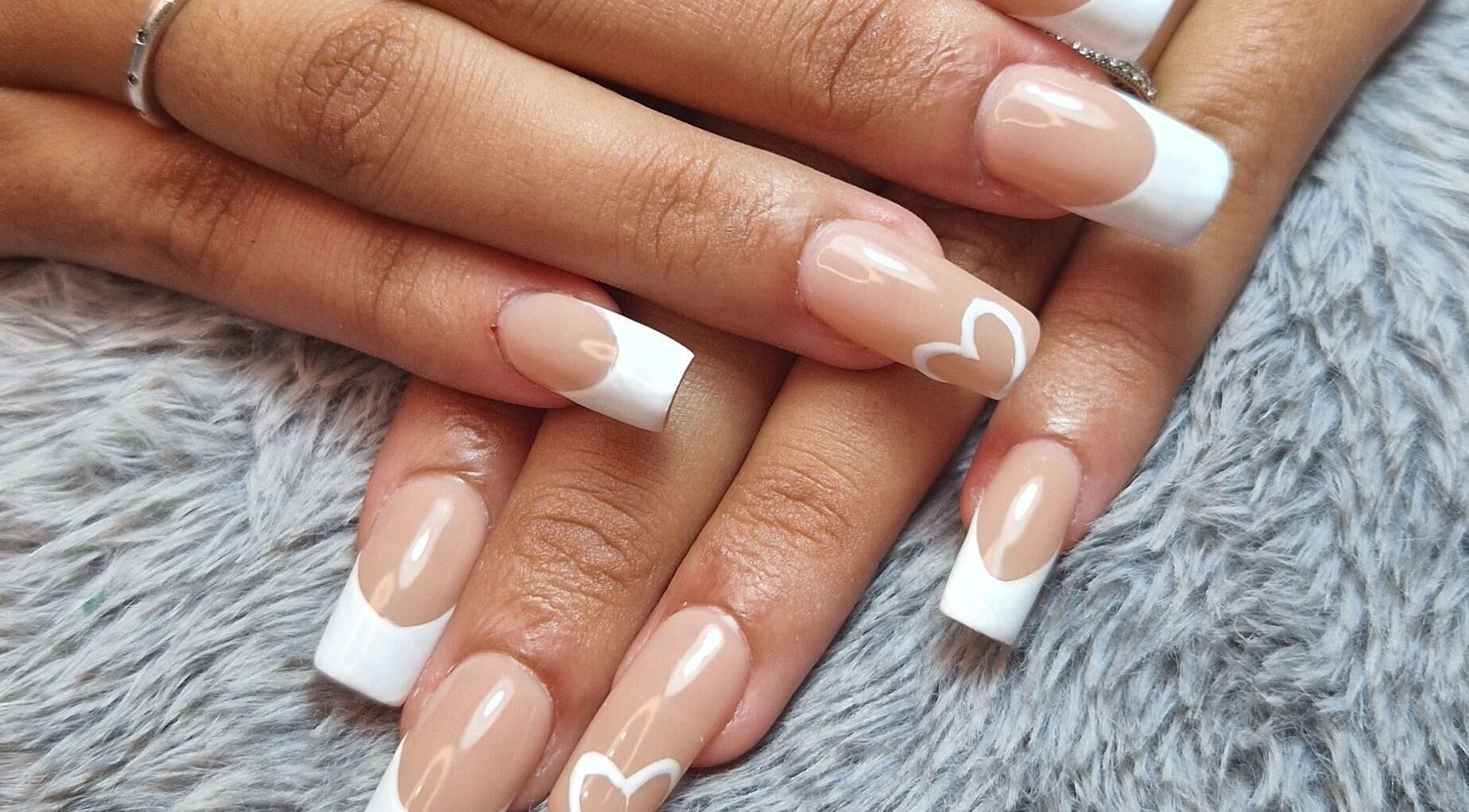 Stylish French manicure with heart design at Ria Dharni, Crawley, England, GB.