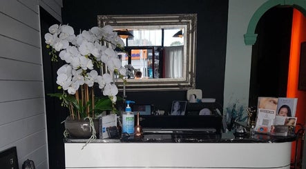 Empire Day Spa reception area in Richmond, Victoria, AU with elegant orchids and a decorative mirror.