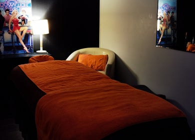 Cozy massage room at Empire Day Spa, Richmond, Victoria, AU, featuring dim lighting and red decor.