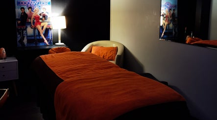 Cozy massage room at Empire Day Spa, Richmond, Victoria, AU, featuring dim lighting and red decor.