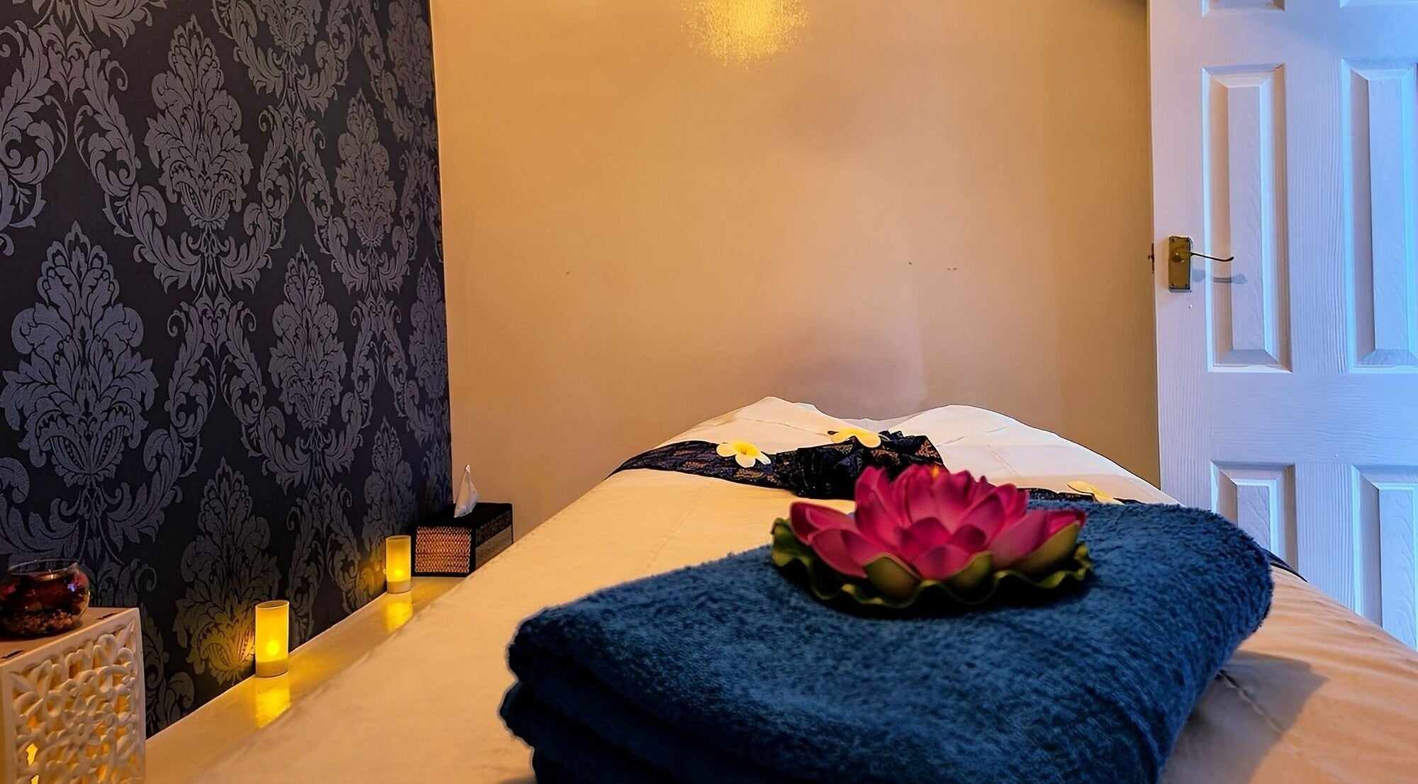 Relaxing massage room at Thai Studio High St Kensington, London, England, GB, featuring candles and a lotus.