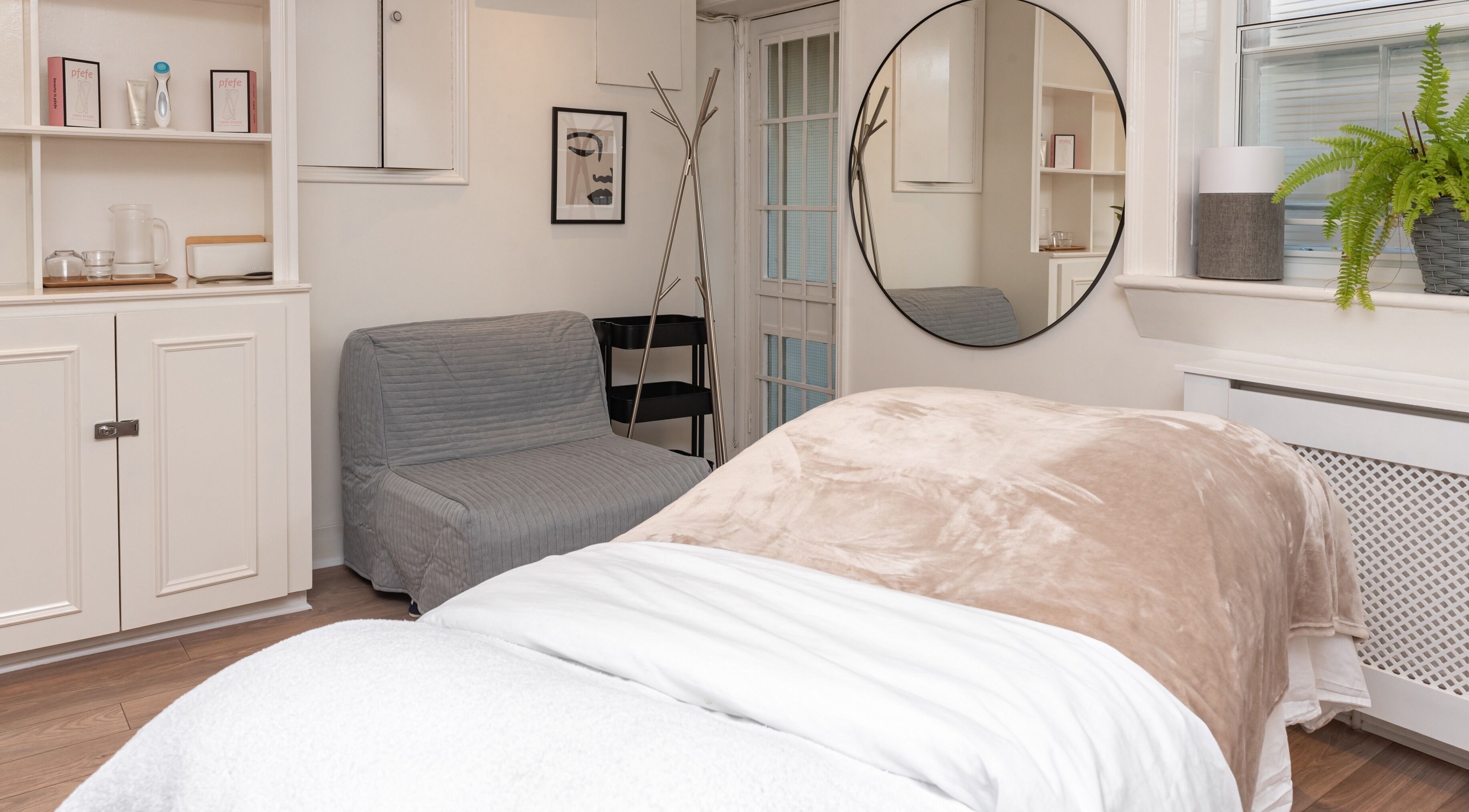 Relaxing treatment room at The Healthy Skin Room, London, England, GB, with cozy bedding and calming decor.