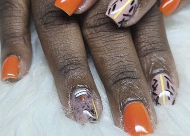 Stylish orange and patterned nails at Jai'sNails, Bridgetown, Saint Michael, BB, showcasing nail art expertise.