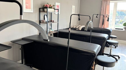 Cosmopolitan Beauty Bar's serene treatment room in Springwater, Ontario, CA, featuring modern massage tables.