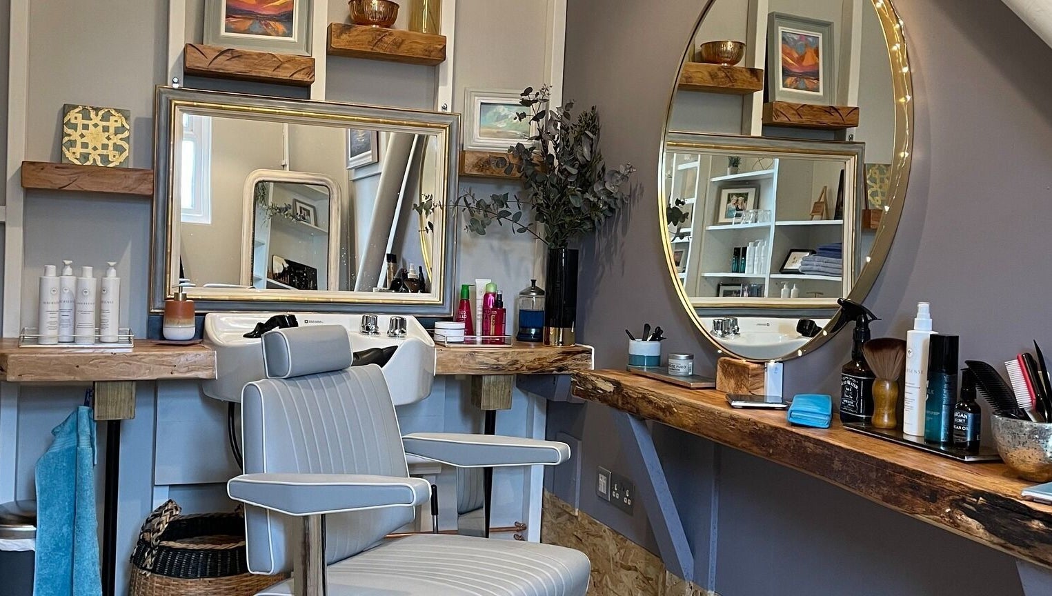 A stylish salon setup at The Curl Studio in Cullompton, England, GB, featuring mirrors and grooming products.