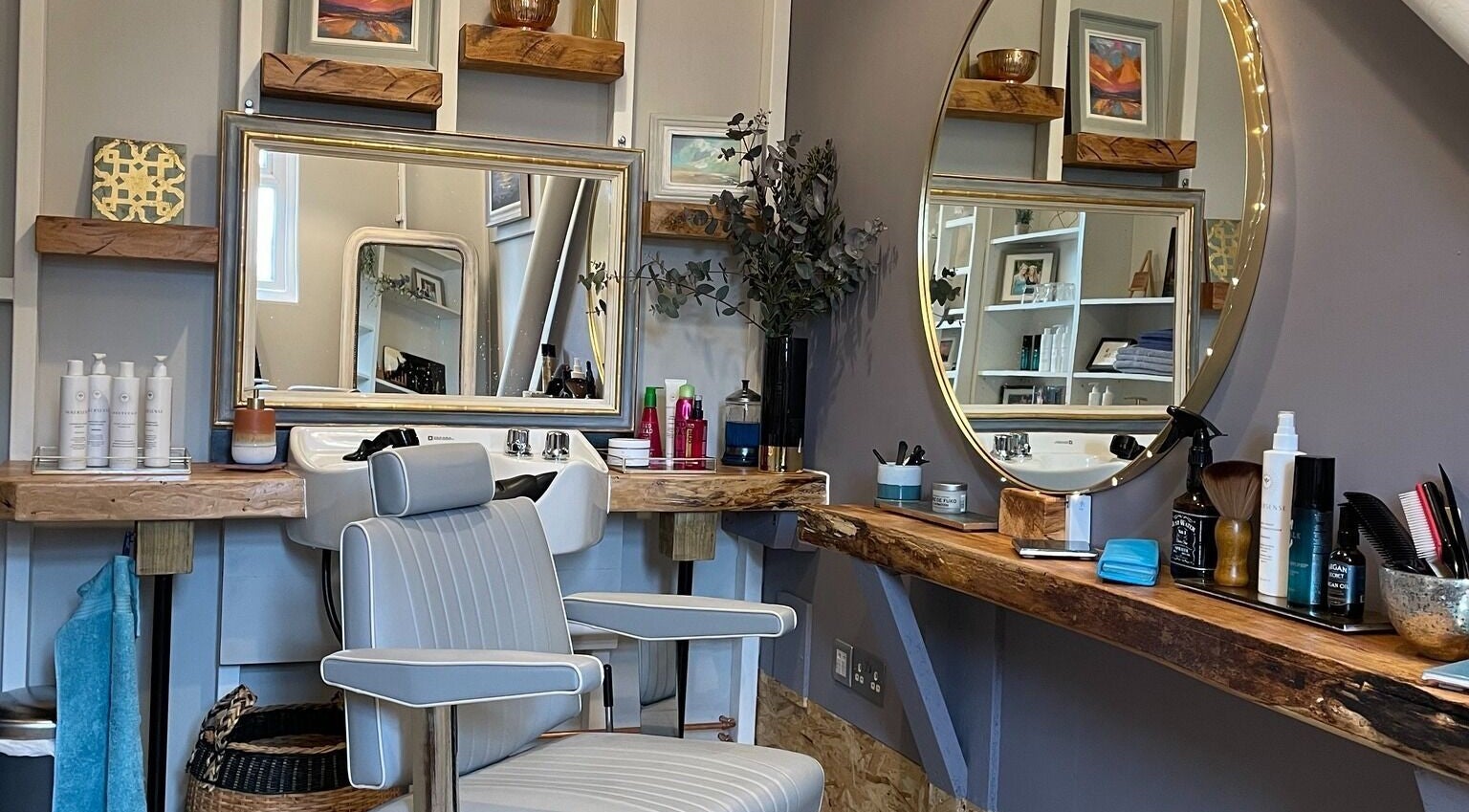 A stylish salon setup at The Curl Studio in Cullompton, England, GB, featuring mirrors and grooming products.