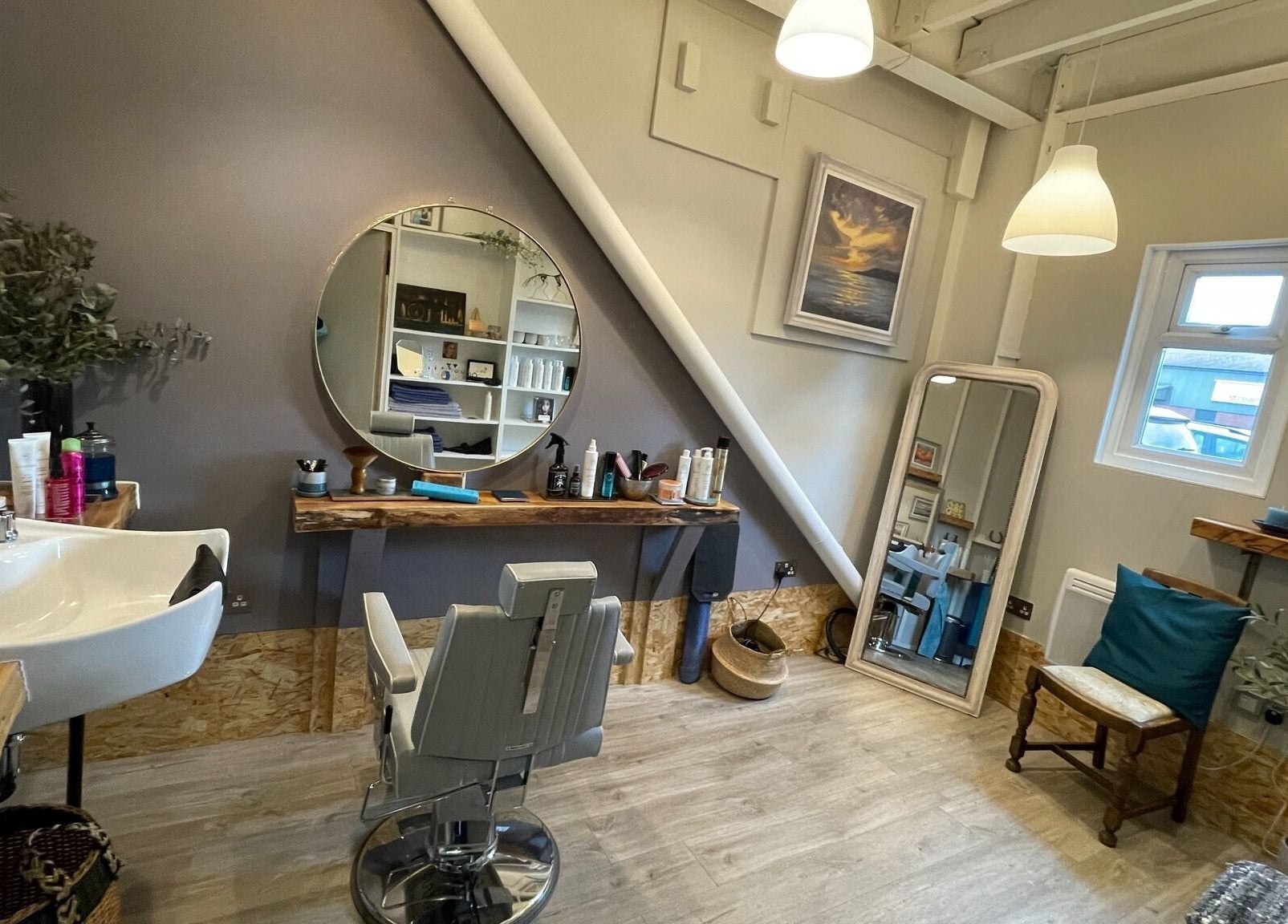 Elegant styling area at The Curl Studio in Cullompton, England, GB. Modern decor with mirrors and comfortable seating.