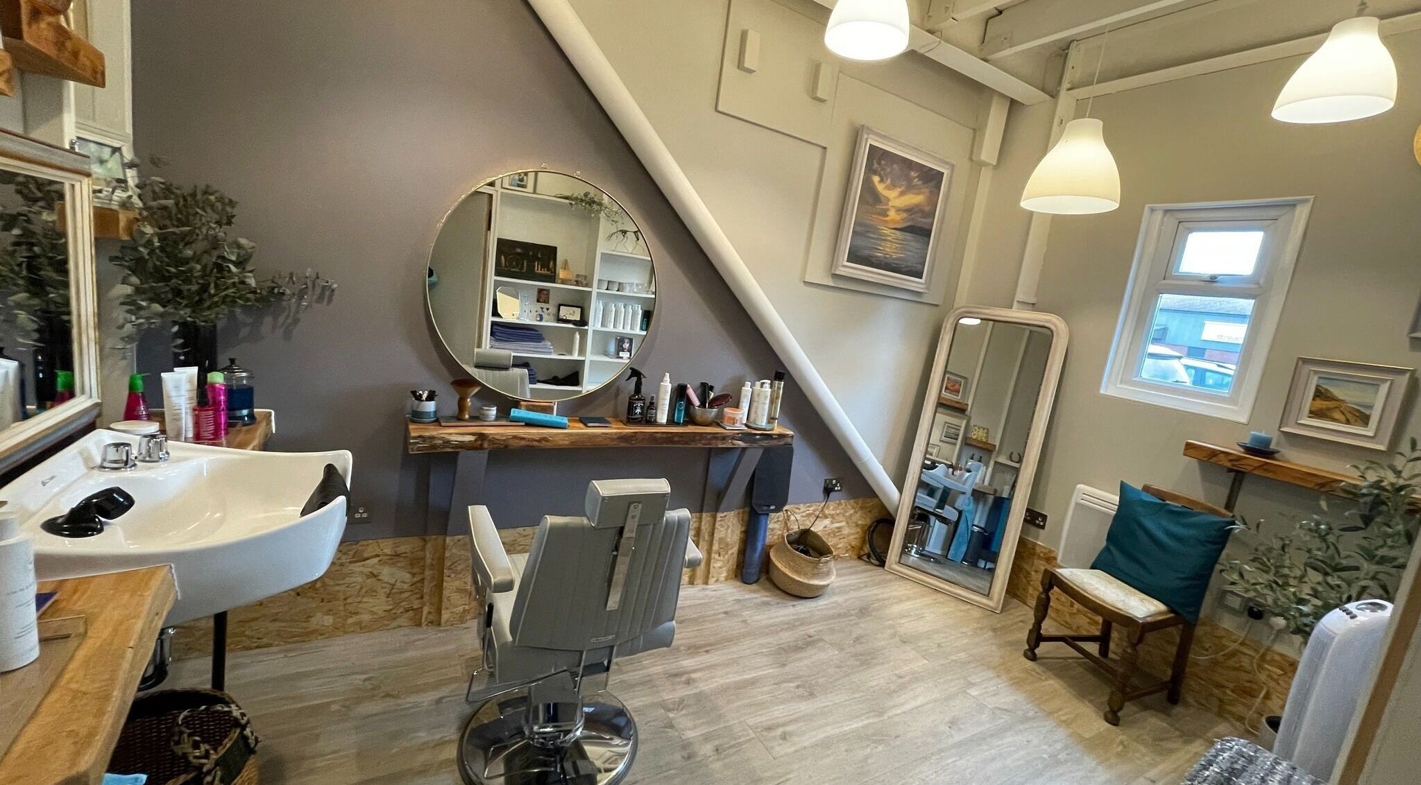 Elegant styling area at The Curl Studio in Cullompton, England, GB. Modern decor with mirrors and comfortable seating.