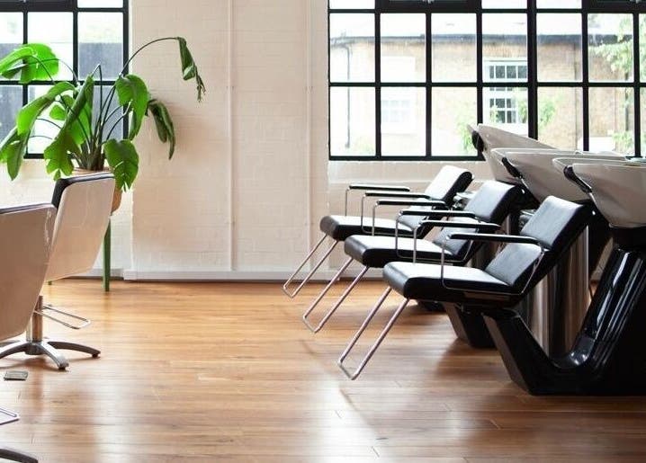 Modern salon interior at Hannah Domney - Hackney, London, England, GB, featuring sleek black wash stations.