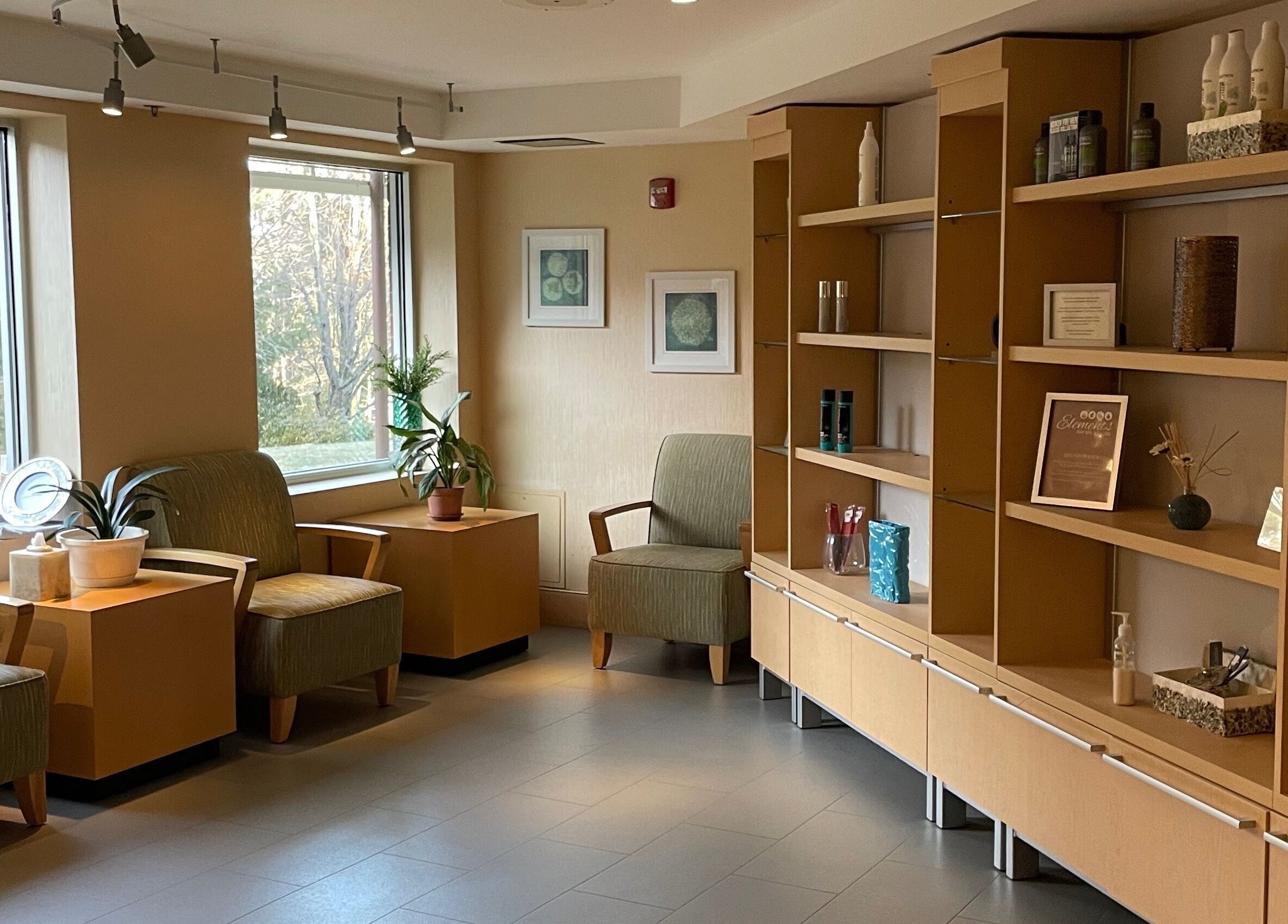 Cozy lounge area at North Hill Elements Day Spa and Salon in Needham, Massachusetts with chairs and decor.