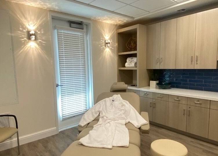 Relaxing spa room at ACOYA Troon Spa Sensi Salon in Scottsdale, Arizona, US. Features a massage table with a robe.