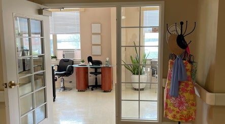 A welcoming entry into Whitney Place Salon, Natick, Massachusetts, US, featuring stylish chairs and decor.