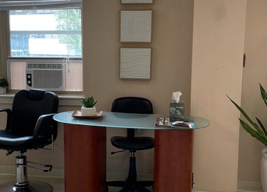 Neat salon station at Whitney Place Salon, Natick, Massachusetts, US with a black chair and modern decor.