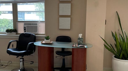 Neat salon station at Whitney Place Salon, Natick, Massachusetts, US with a black chair and modern decor.