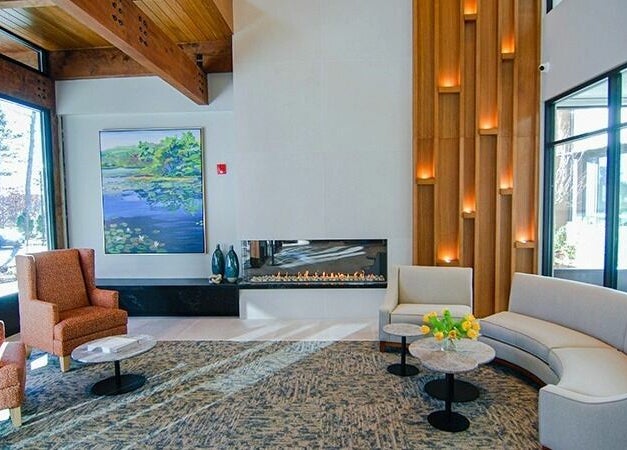 Elegant lobby at Cordwainer Bliss Salon, Norwell, Massachusetts, US with cozy seating and a modern fireplace.