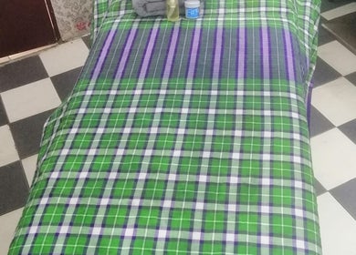 Massage table at Aora Spa and Wellness Kuala Langat in Telok Panglima Garang, Selangor, MY with green plaid cover.