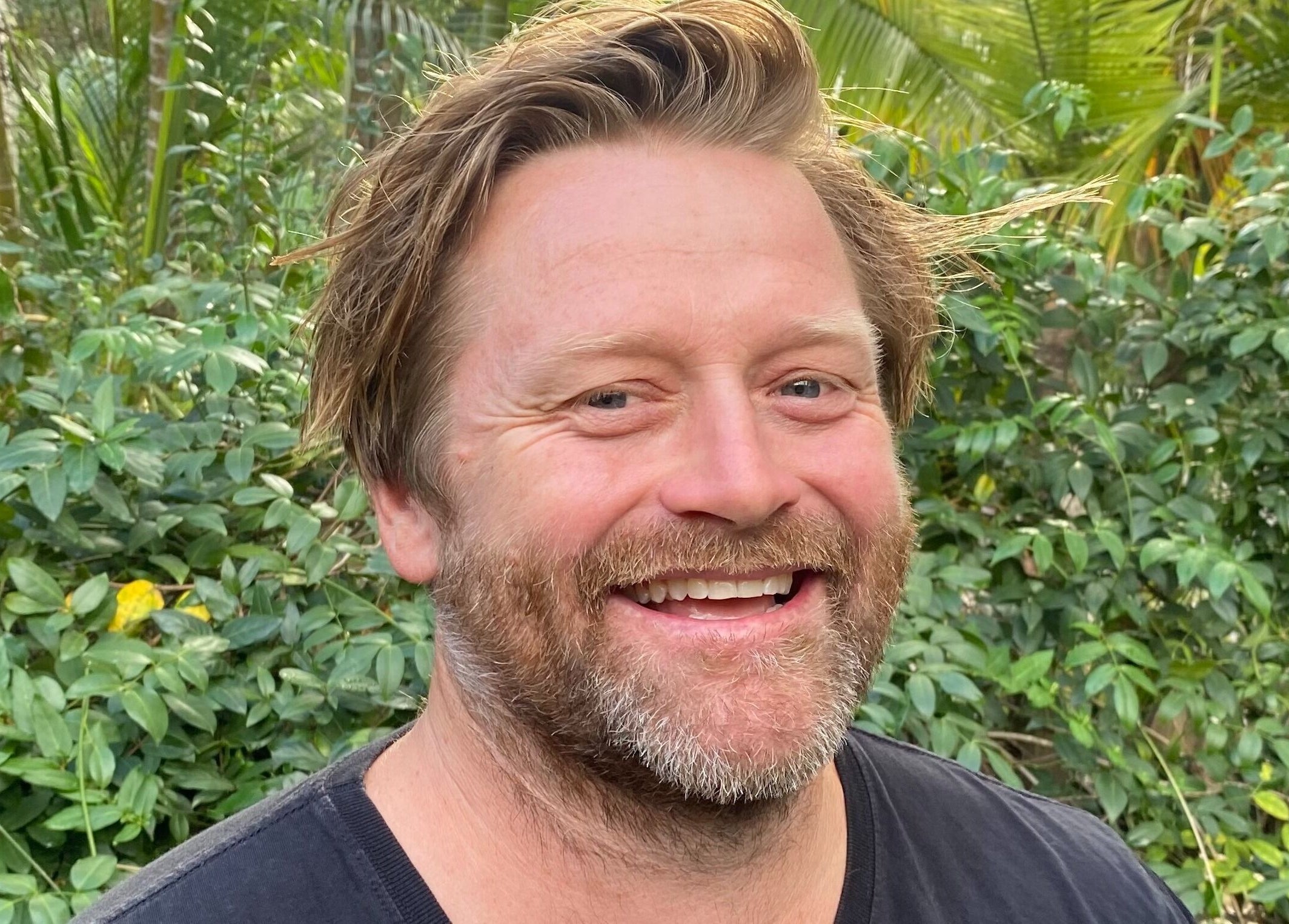 Person smiling amidst lush greenery at Amaroo Wellness, Landers Shoot, Queensland, AU.