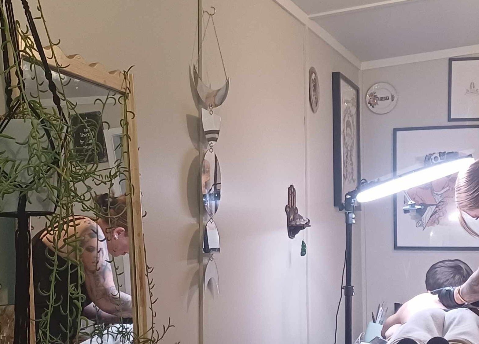 Stylish tattoo session at Made&Marked by AmyLouise, Whangarei, Northland, NZ with decorative mirrors and plants.