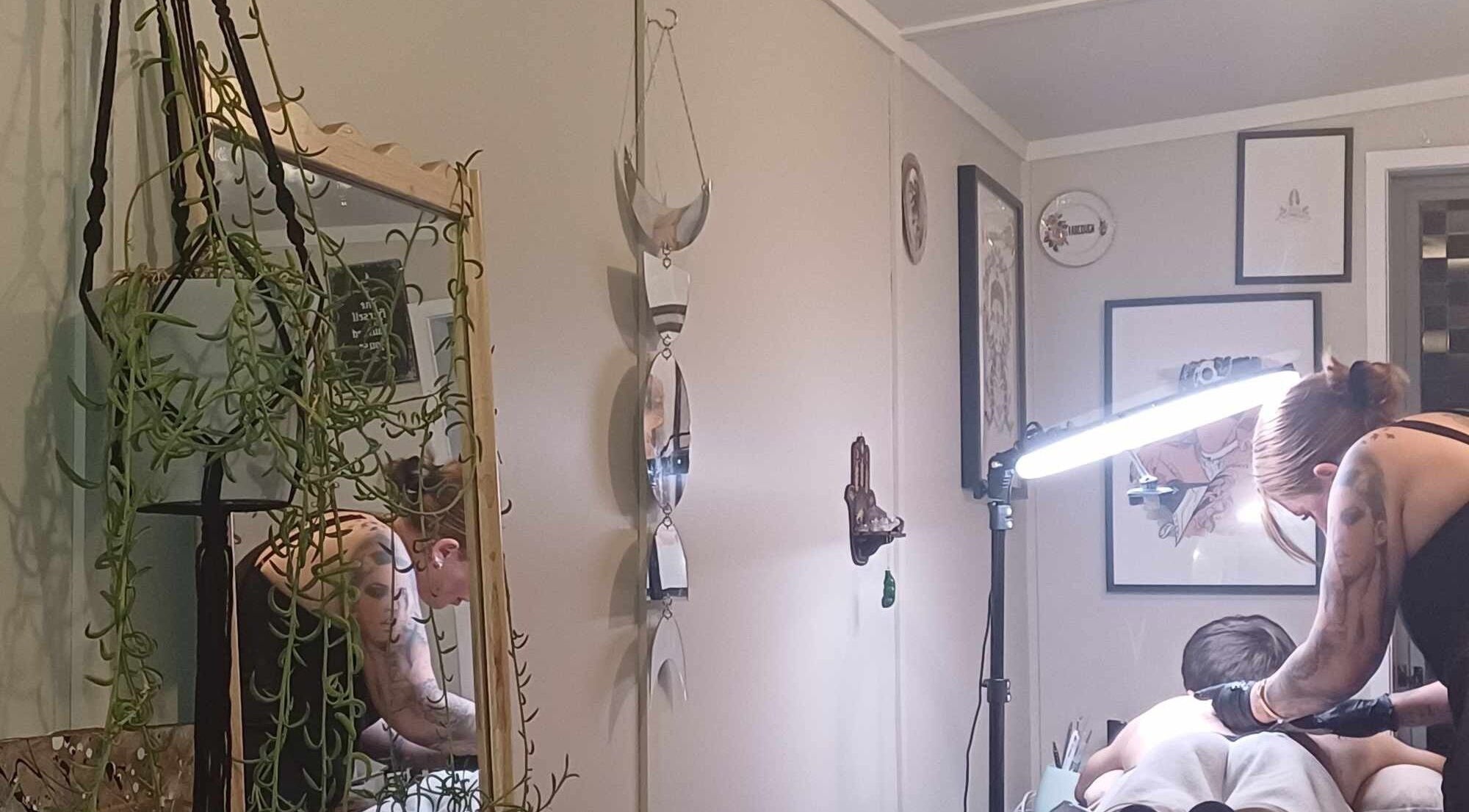 Stylish tattoo session at Made&Marked by AmyLouise, Whangarei, Northland, NZ with decorative mirrors and plants.