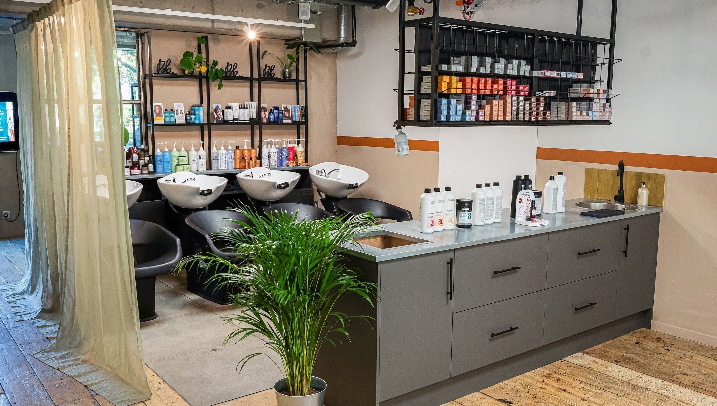 Modern salon interior at Chop Chop London Camden, London, England, GB with sleek wash stations and vibrant products.