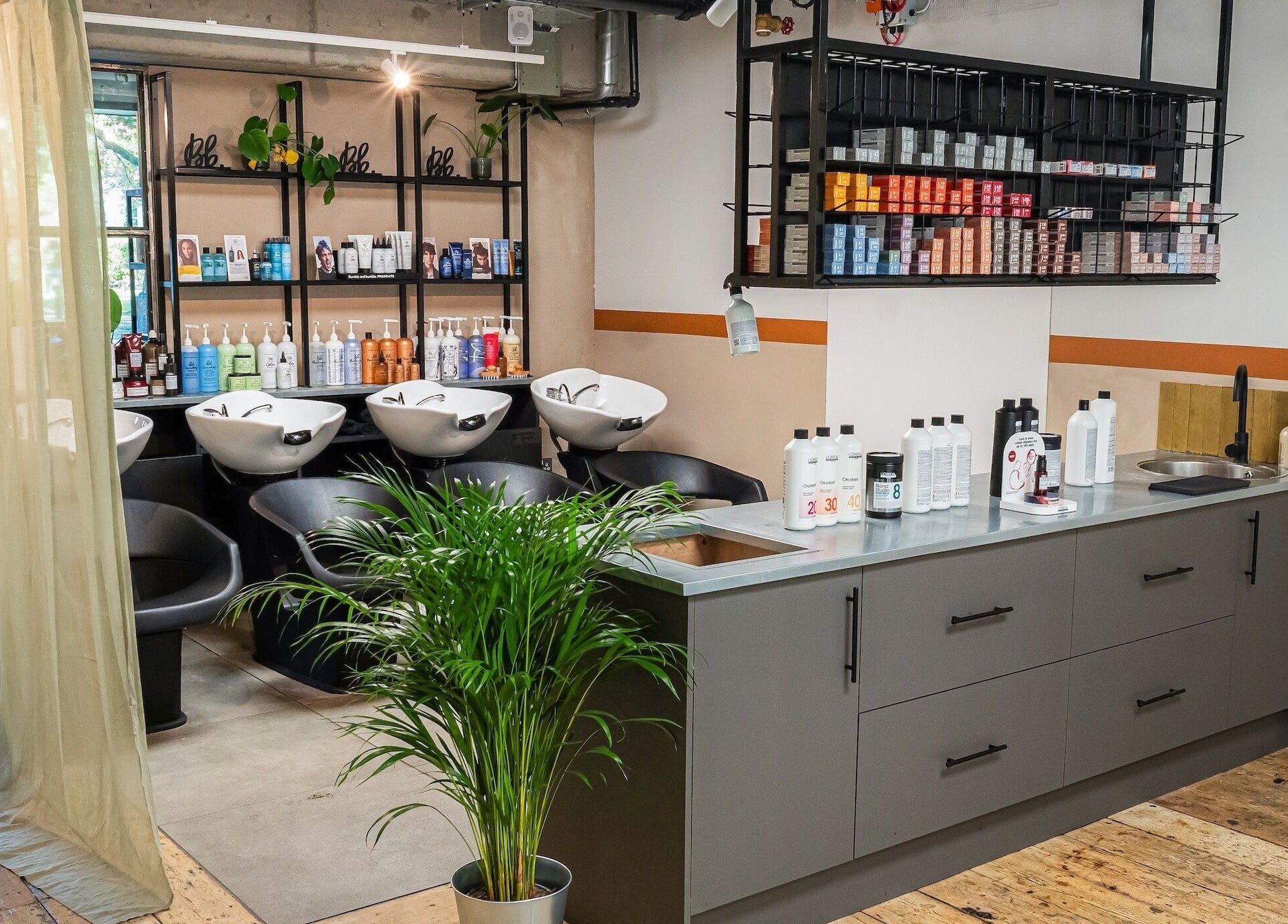 Modern salon interior at Chop Chop London Camden, London, England, GB with sleek wash stations and vibrant products.