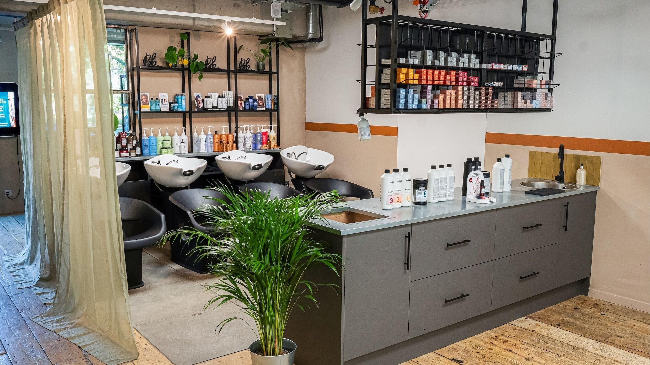 Modern salon interior at Chop Chop London Camden, London, England, GB with sleek wash stations and vibrant products.