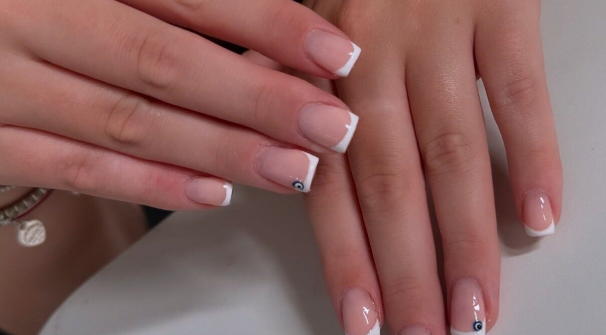 Stylish French manicure at Lucisbeautyroom, Redlodge, England, GB. Elegant nail art design displayed.