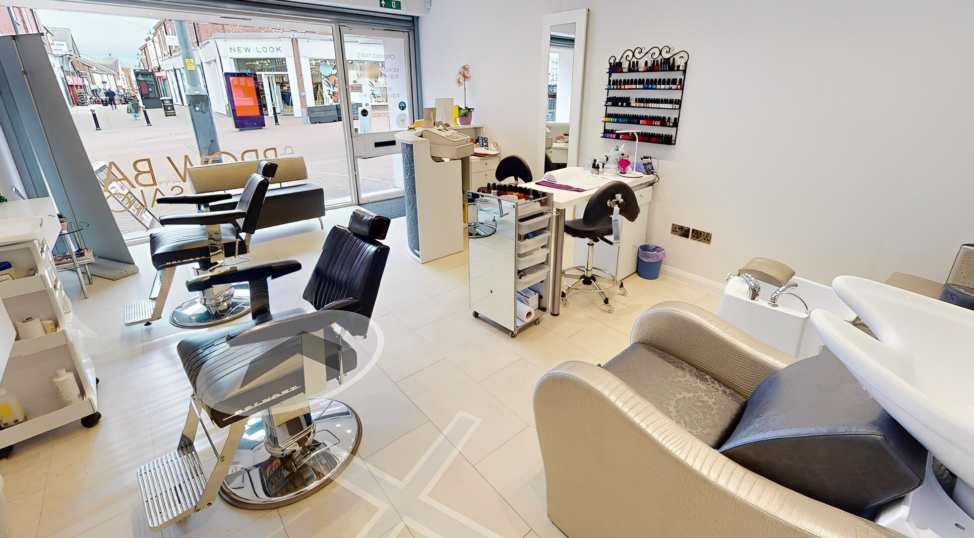 Inside VIP Brow Bar and Salon, Newcastle-under-Lyme, England, showcasing sleek styling chairs and manicure station.