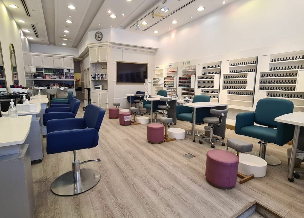 Stylish nail care area at Front Row Salon, Dubai, AE, with modern seating and expansive polish display.