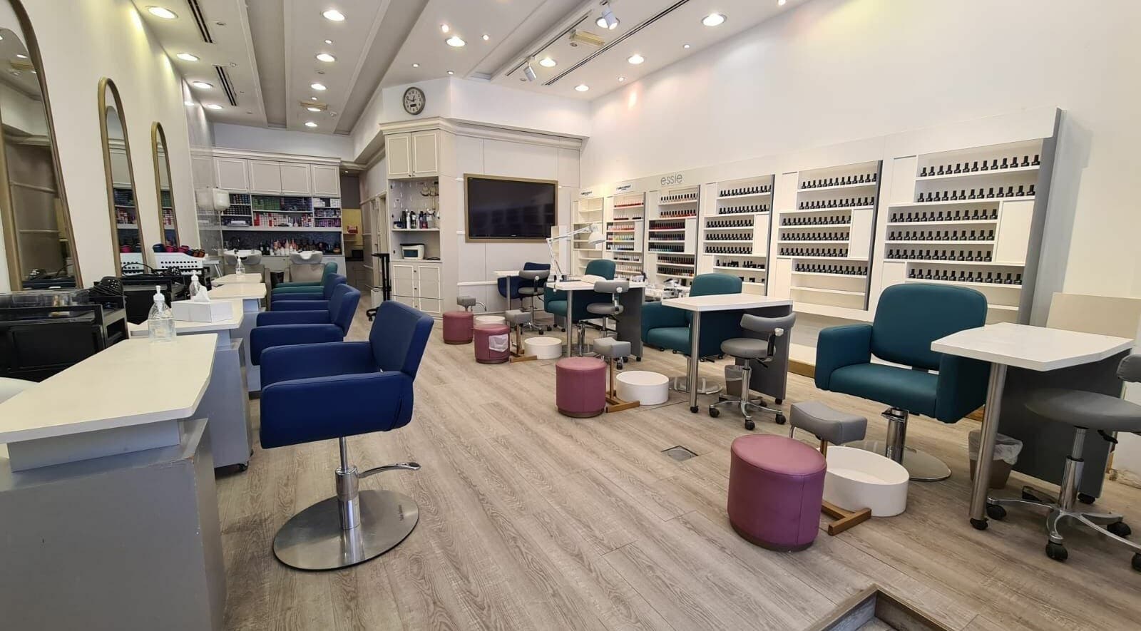 Stylish nail care area at Front Row Salon, Dubai, AE, with modern seating and expansive polish display.