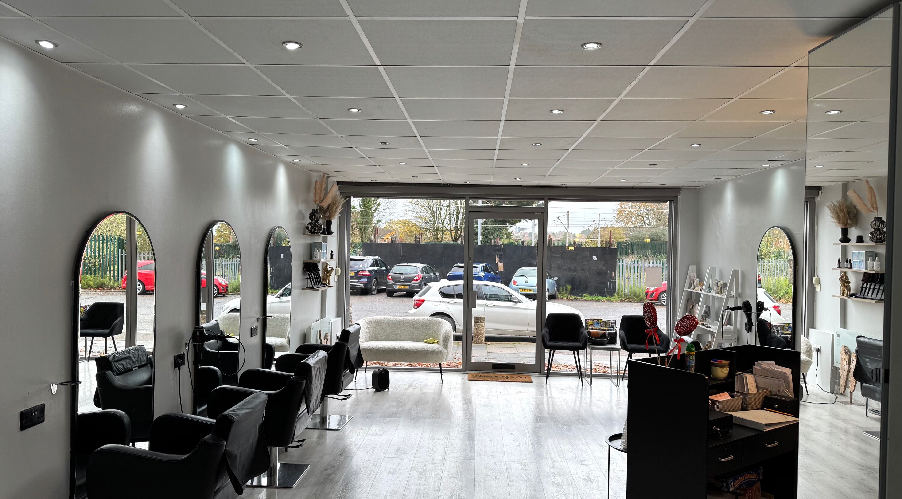 Modern salon interior at By Olivia Hines in Barnet, England, GB with stylish mirrors and seating.
