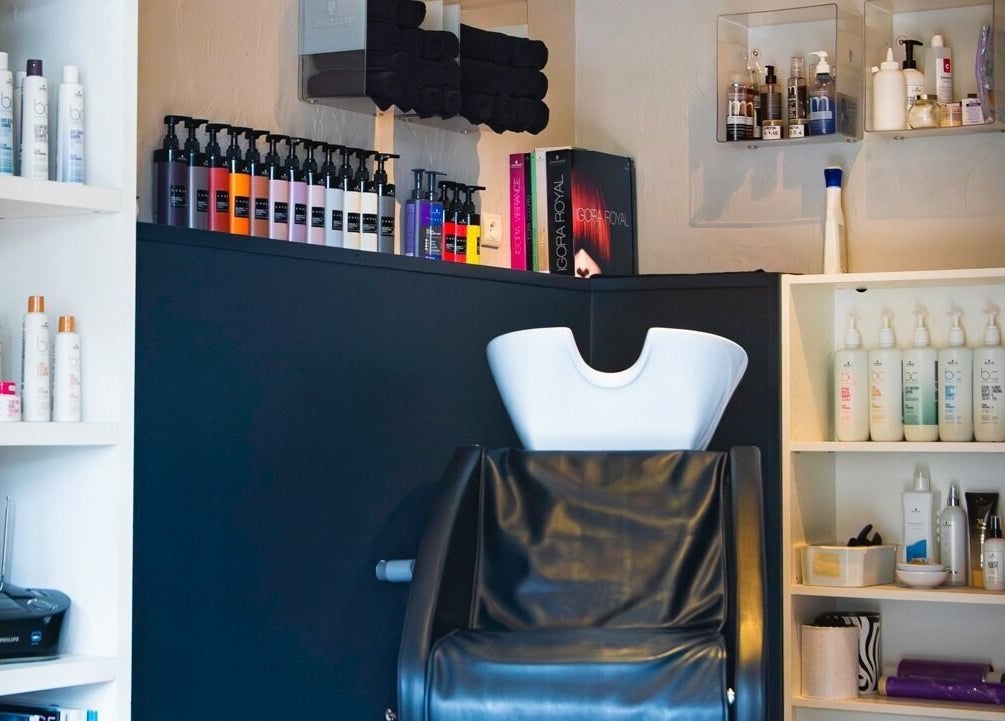 Espace de soins chic chez Imagin'hair, Bains, Auvergne-rhône-alpes, FR avec produits et fauteuil moderne.