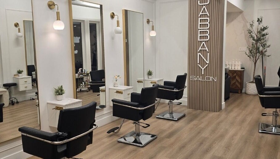 Stylish interior of Hair By Dawn at Jabbany Hair Salon, Ottawa, Ontario, CA featuring sleek black chairs and mirrors.