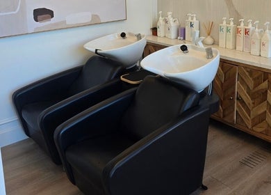 Modern wash stations at Hair By Dawn in Jabbany Hair Salon, Ottawa, Ontario, CA, showcasing stylish black chairs.