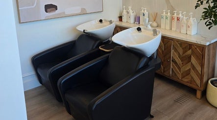 Modern wash stations at Hair By Dawn in Jabbany Hair Salon, Ottawa, Ontario, CA, showcasing stylish black chairs.