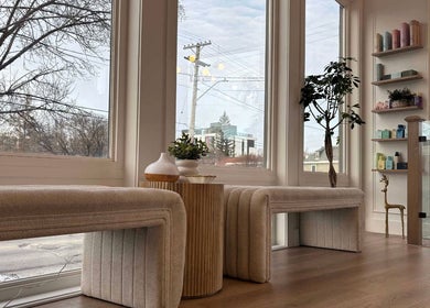 Relaxing seating area at Hair By Dawn at Jabbany Hair Salon, Ottawa, Ontario, CA with large windows and product shelves.