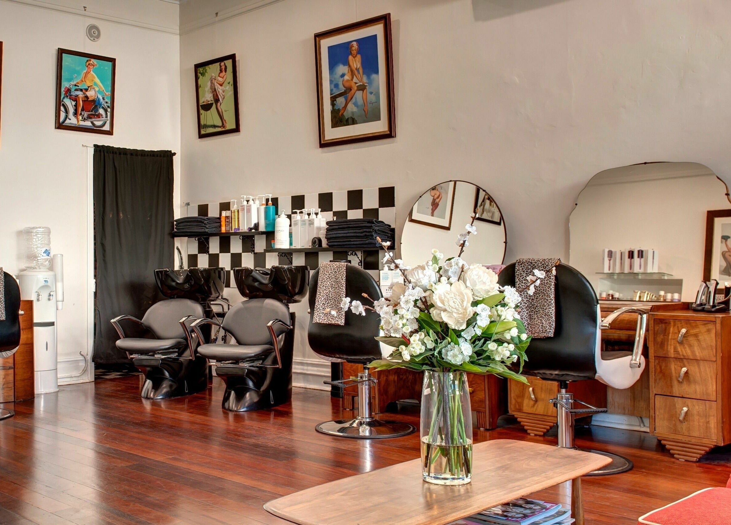 Elegant interior of Doowop Hair, Fremantle, Western Australia, AU with modern chairs and floral decor.