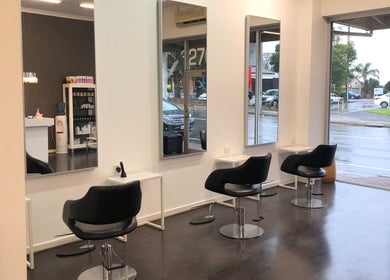 Sleek salon chairs and mirrors at Beyond Blonde, Adelaide, South Australia, AU, offering modern beauty services.