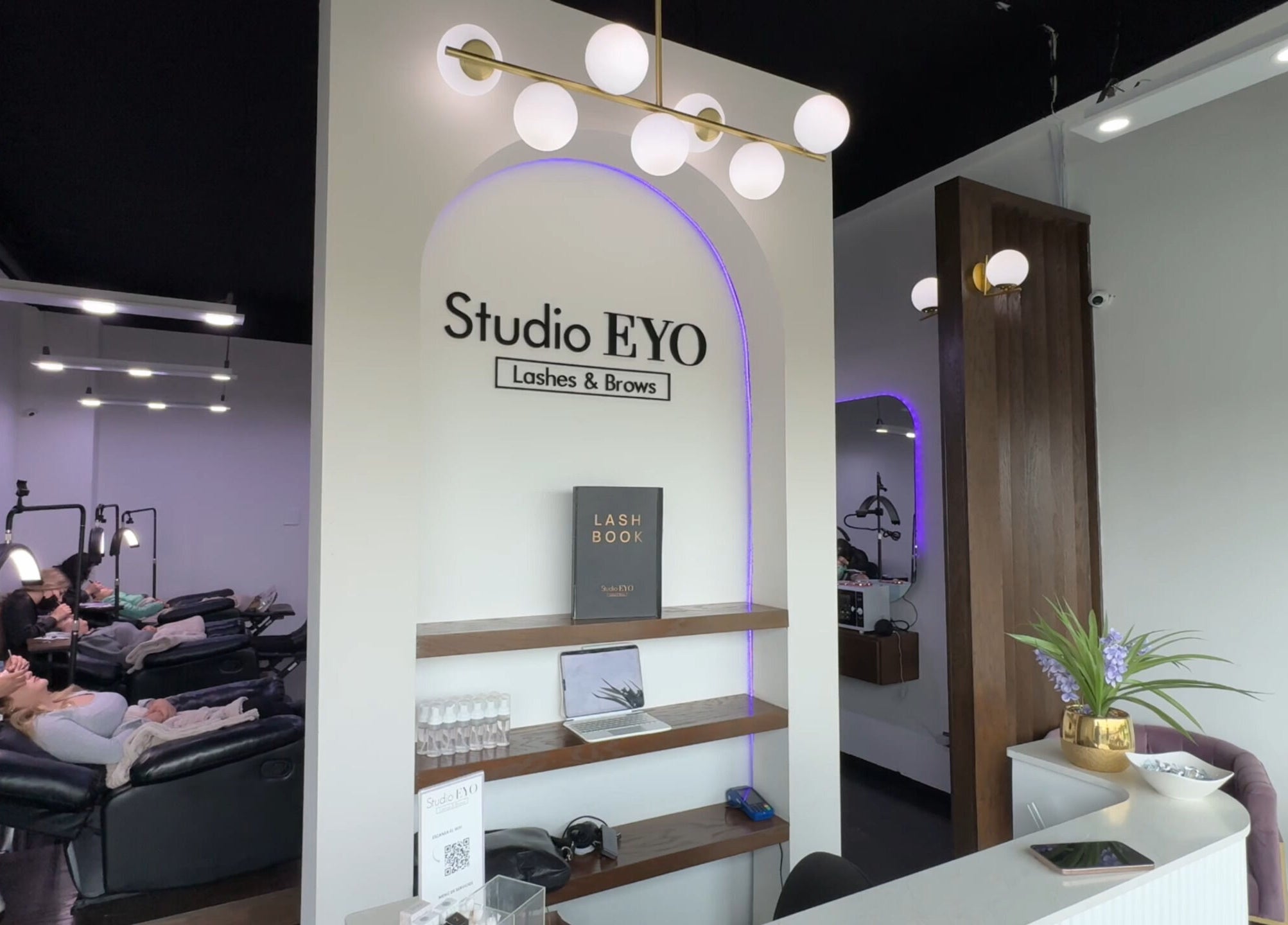 Interior moderno de Studio Eyo en Chihuahua, Chihuahua, MX, con sillas de belleza y decoración elegante.