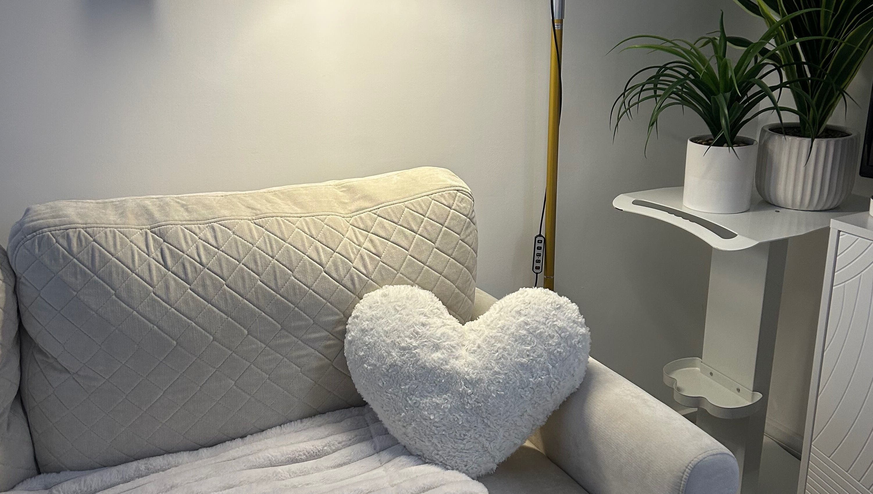 Chic sofa with heart pillow at Laura Dix Mentoring, Ebbw Vale, Wales, GB. Modern decor with plants.