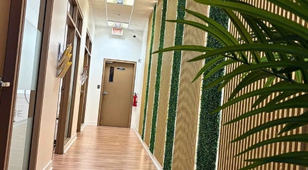 Couloir moderne de Épilation l’élégance à Brossard, Québec, CA, avec murs texturés et plantes vertes.