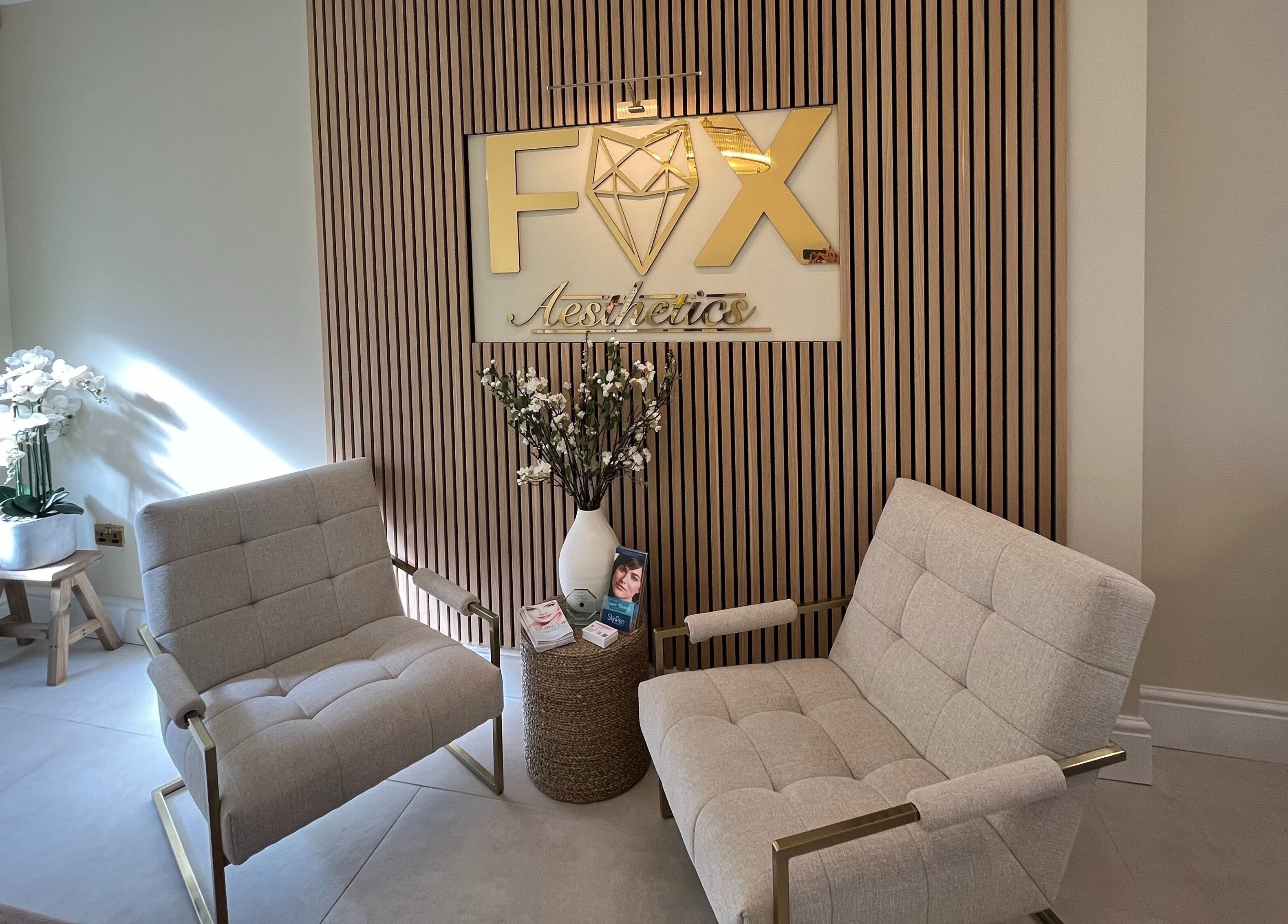 Stylish waiting area at Fox Aesthetics, Bridgend, Wales, GB with comfortable chairs and elegant decor.