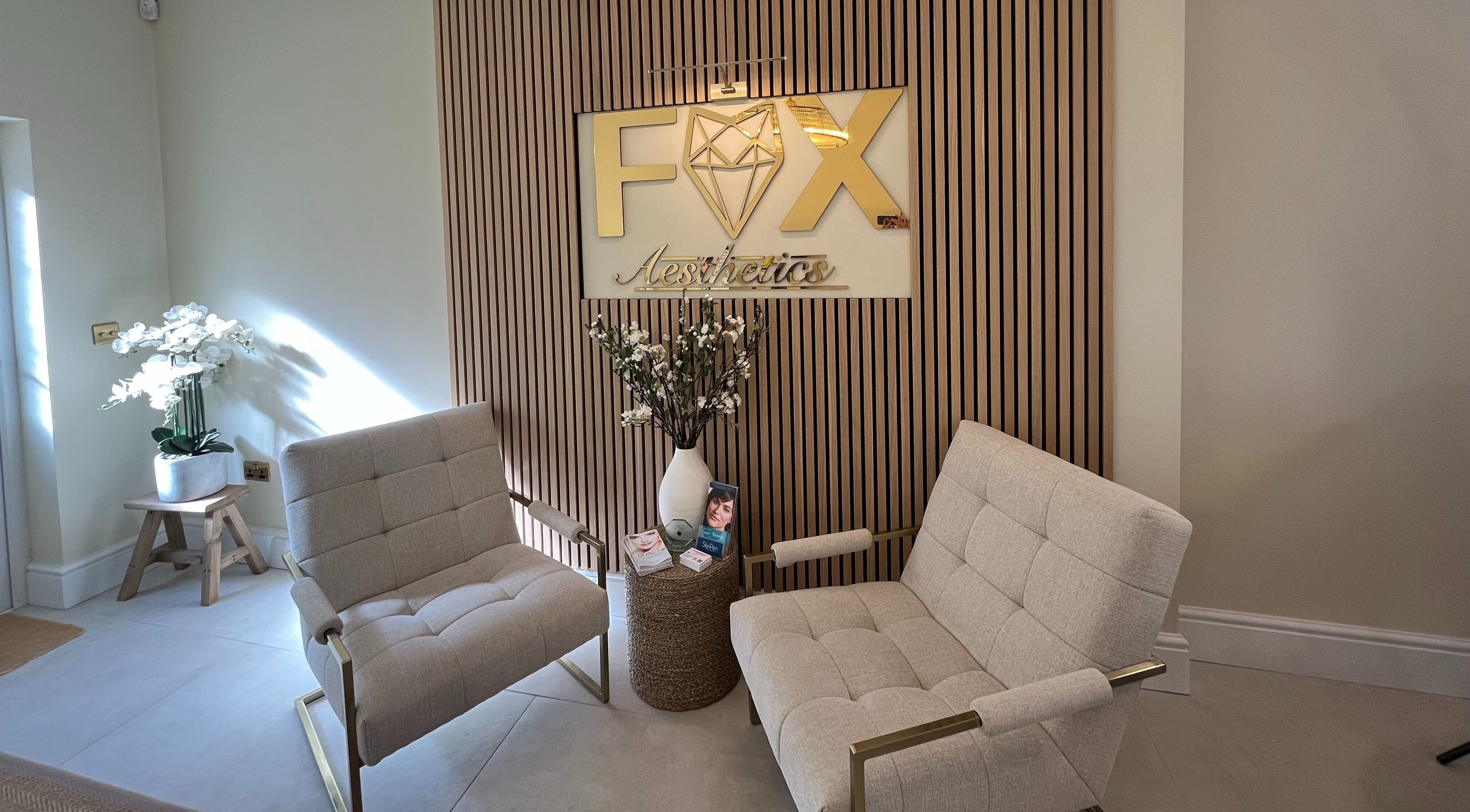 Stylish waiting area at Fox Aesthetics, Bridgend, Wales, GB with comfortable chairs and elegant decor.