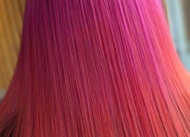 Vibrant pink and orange hair at All About You, Armadale, Scotland, GB. Showcasing latest hairstyle trends.