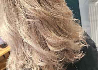 Elegant blonde wavy hairstyle at All About You in Armadale, Scotland, GB.