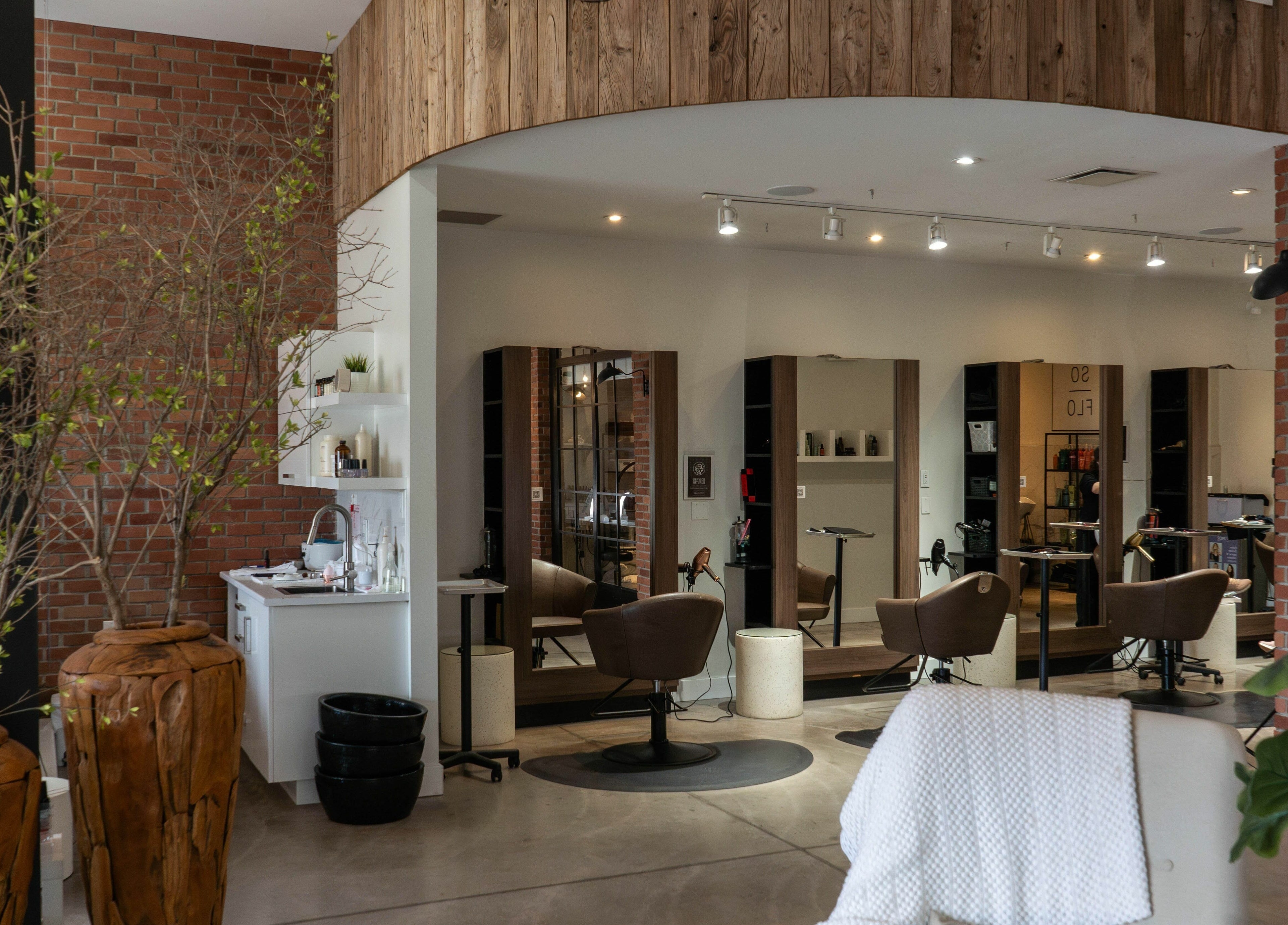 Stylish interior of SoFlo & Co North in Moncton, New Brunswick, CA with modern salon chairs and rustic decor.